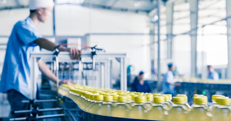 Un trabajador de la industria de bebidas en una línea de producción.